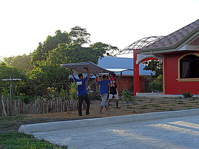 carrying sheets of new roofing material in the philippines