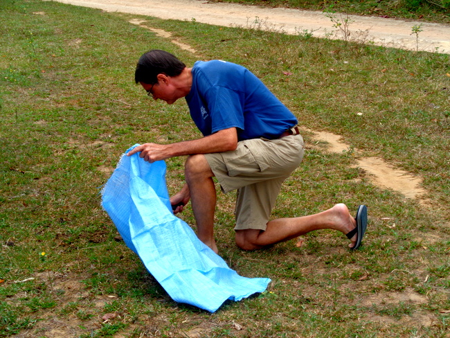 Captain Tom scooping up cow poop in Gumaras